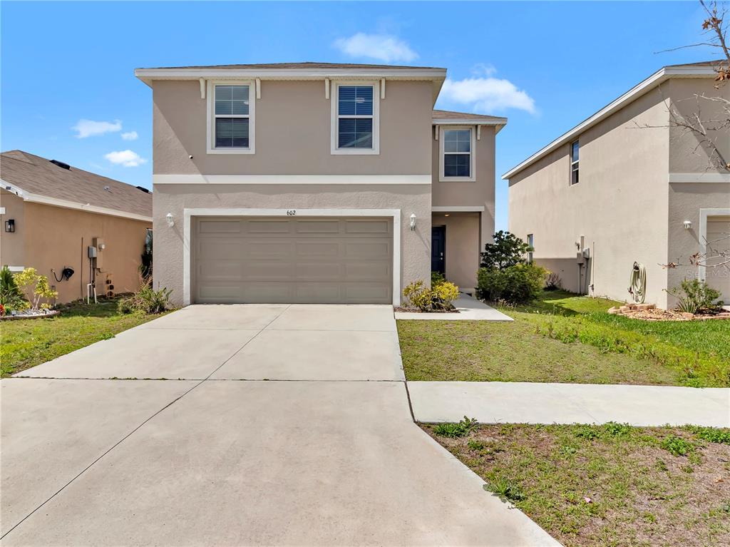 a front view of a house with a yard and garage