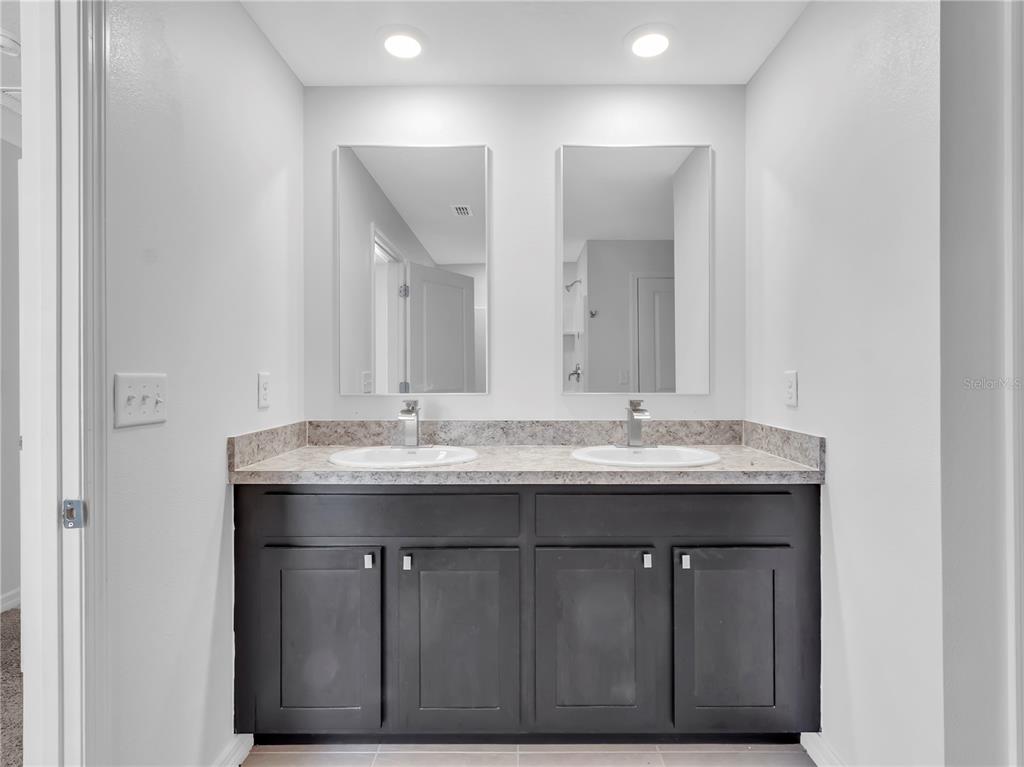 602 Olive Conch Street Ruskin, FL 33570 - Photo 13 of 23 a bathroom with a granite countertop sink and a mirror