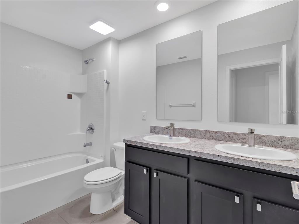 602 Olive Conch Street Ruskin, FL 33570 - Photo 14 of 23 a bathroom with a granite countertop sink toilet and shower