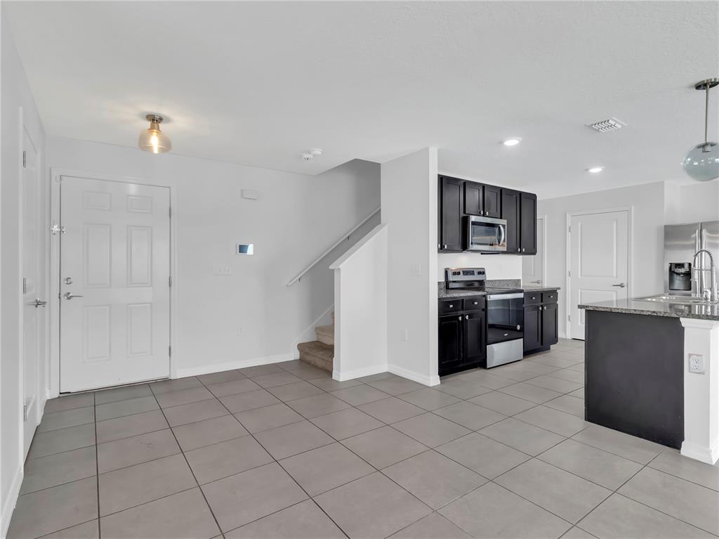 602 Olive Conch Street Ruskin, FL 33570 - Photo 4 of 23 a kitchen with stainless steel appliances a refrigerator sink and microwave