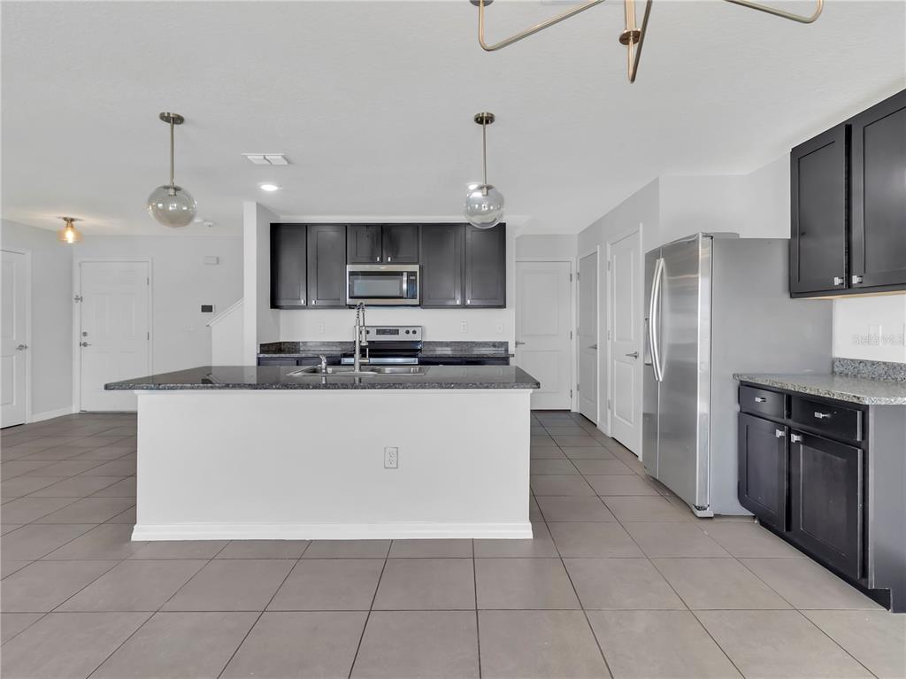 602 Olive Conch Street Ruskin, FL 33570 - Photo 5 of 23 a large kitchen with stainless steel appliances a refrigerator a stove top oven a sink dishwasher and white cabinets