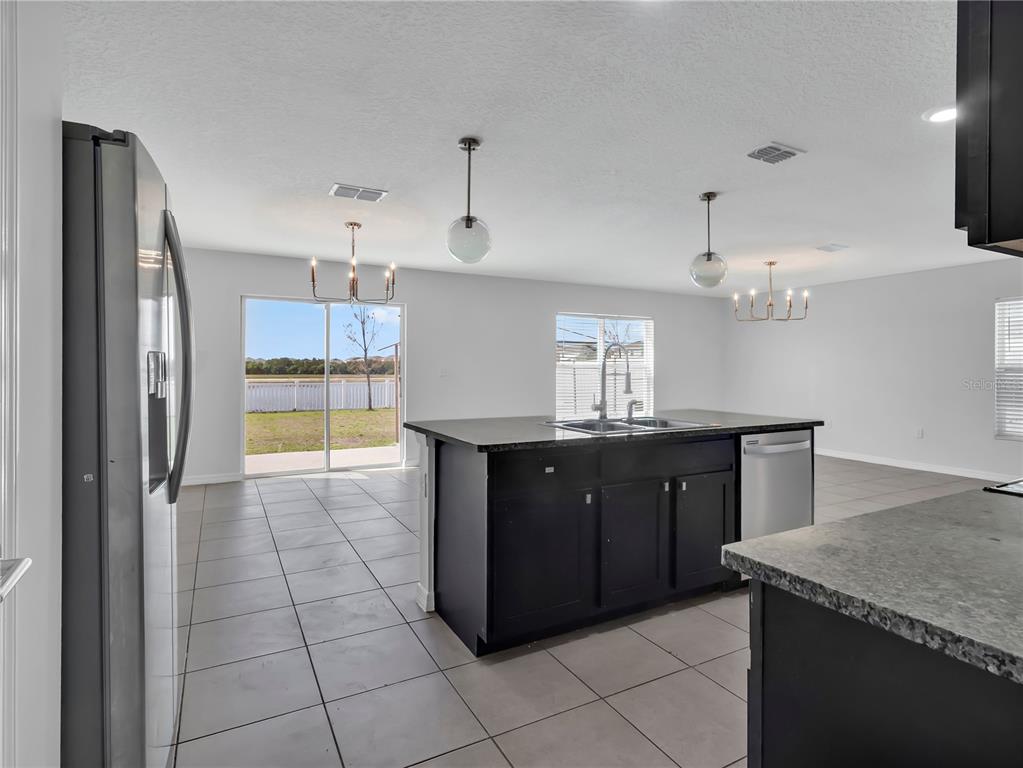 602 Olive Conch Street Ruskin, FL 33570 - Photo 6 of 23 a kitchen with granite countertop a refrigerator and a sink
