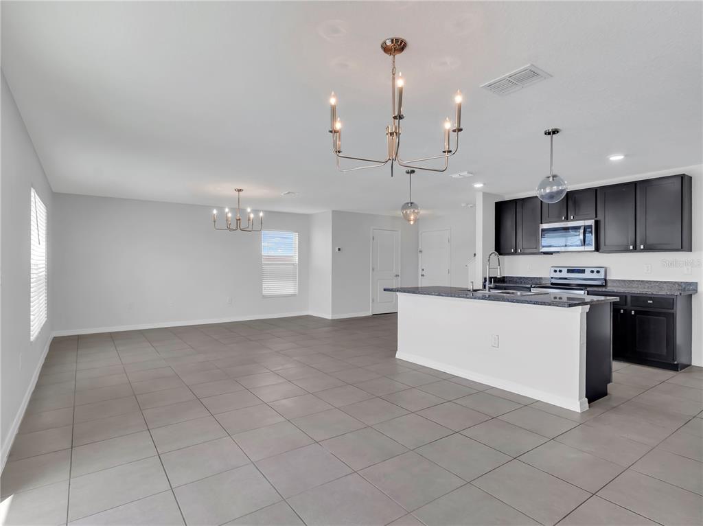 602 Olive Conch Street Ruskin, FL 33570 - Photo 7 of 23 a large white kitchen with a stove a sink a microwave and a refrigerator