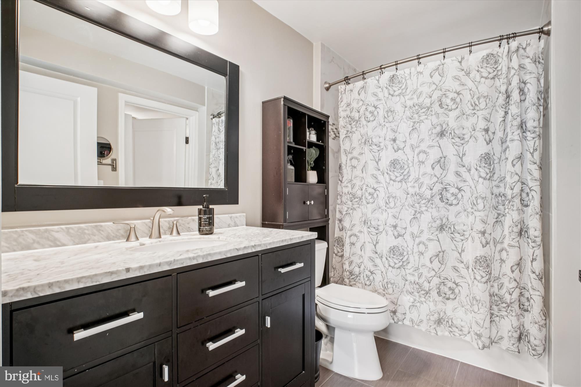 12000 Market Street, Unit 415 Reston, VA 20190 - Photo 16 of 34 a bathroom with a granite countertop sink a toilet and a mirror
