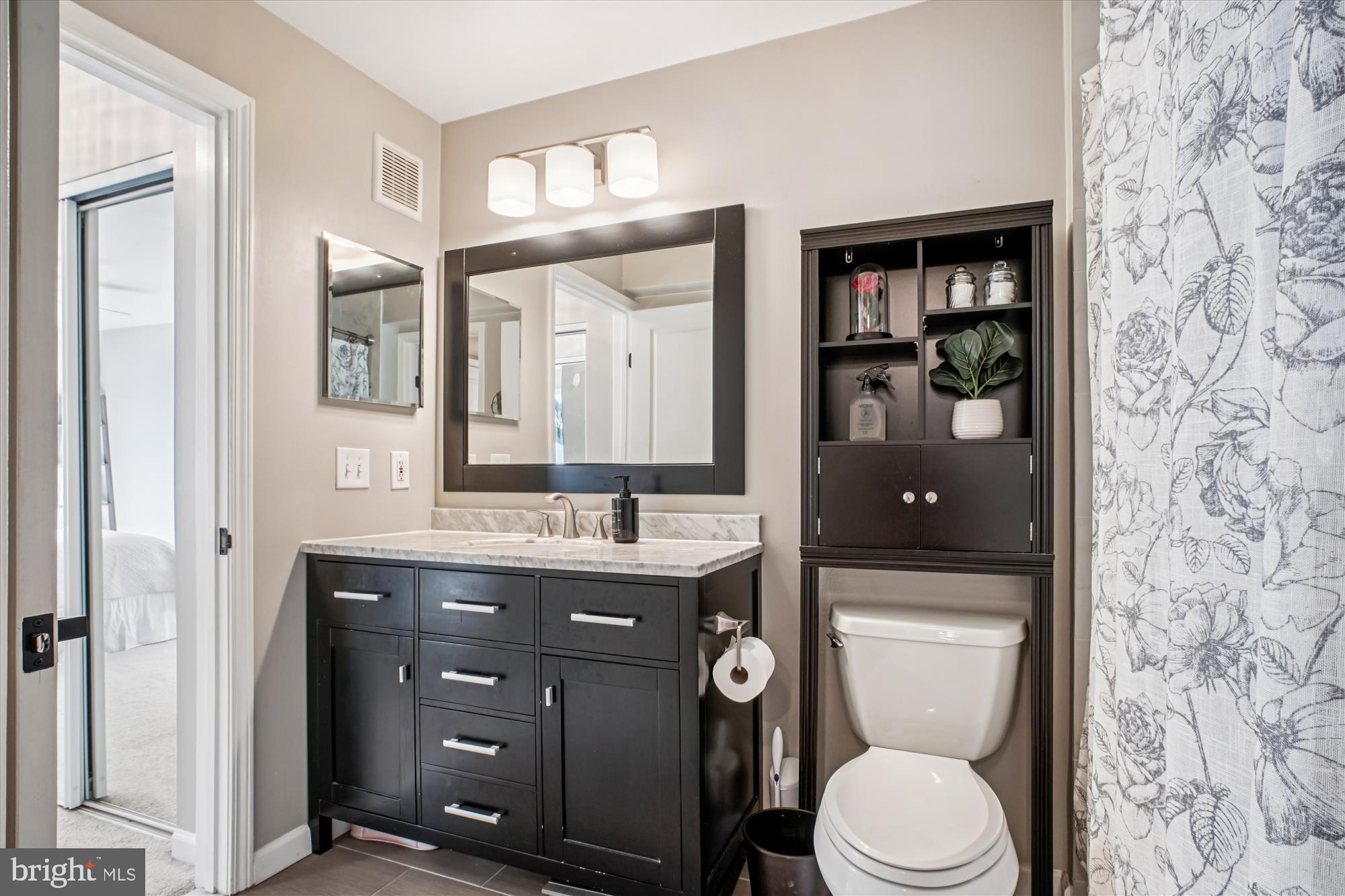 12000 Market Street, Unit 415 Reston, VA 20190 - Photo 17 of 34 a bathroom with a granite countertop toilet sink and mirror
