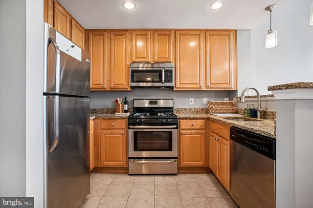 a kitchen with stainless steel appliances granite countertop a refrigerator stove and sink
