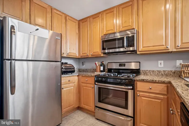 a kitchen with stainless steel appliances granite countertop a refrigerator stove and microwave