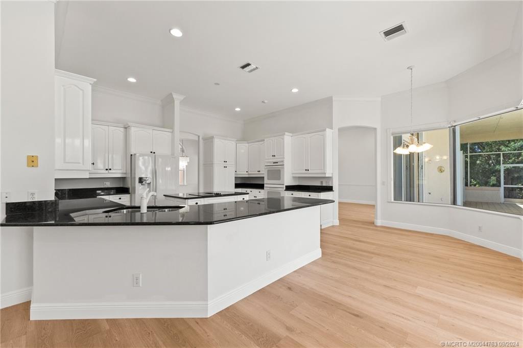 60 North River Road Stuart, FL 34996 - Photo 26 of 74 a large kitchen with stainless steel appliances a large counter top a stove and a refrigerator