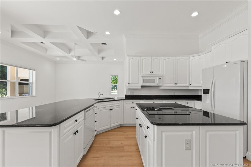 60 North River Road Stuart, FL 34996 - Photo 27 of 74 a kitchen with granite countertop a sink and cabinets