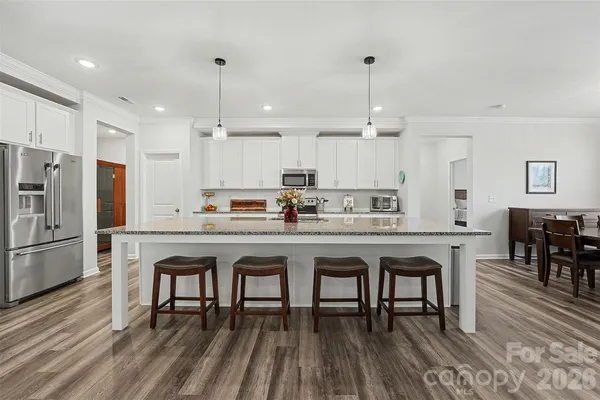 a kitchen with kitchen island granite countertop a sink a center island and stainless steel appliances