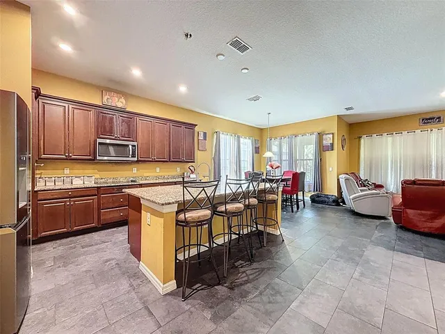 a kitchen with stainless steel appliances granite countertop a sink and a refrigerator