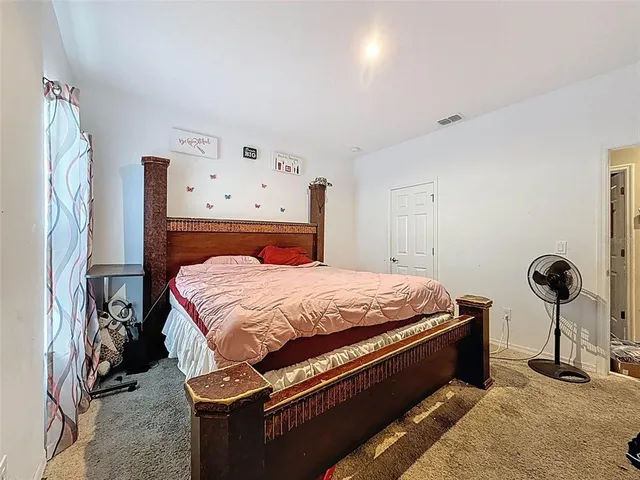 a bedroom with bed tv and window