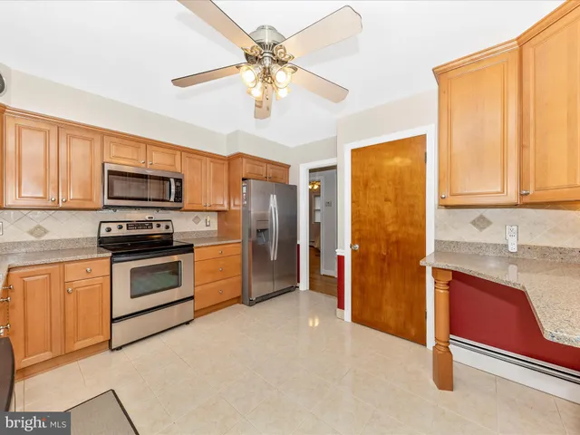 a kitchen with stainless steel appliances granite countertop a stove refrigerator and microwave