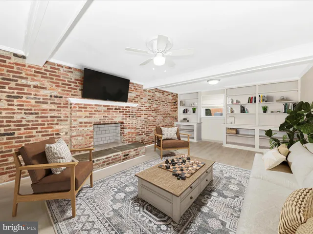 a view of a livingroom with a fireplace a chandelier a wooden table and chairs
