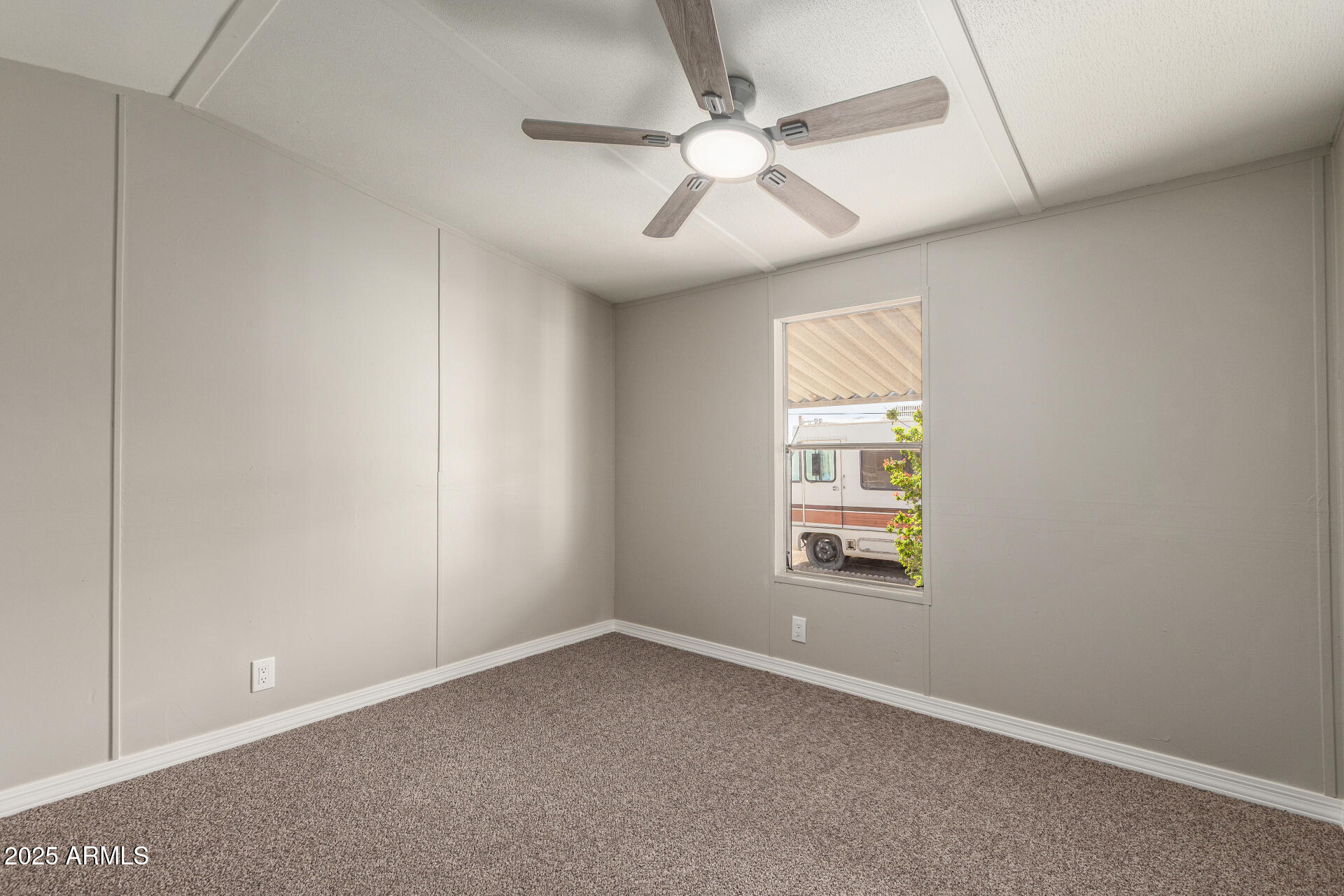 1730 East 21st Avenue Apache Junction, AZ 85119 - Photo 17 of 25 an empty room with a window and ceiling fan