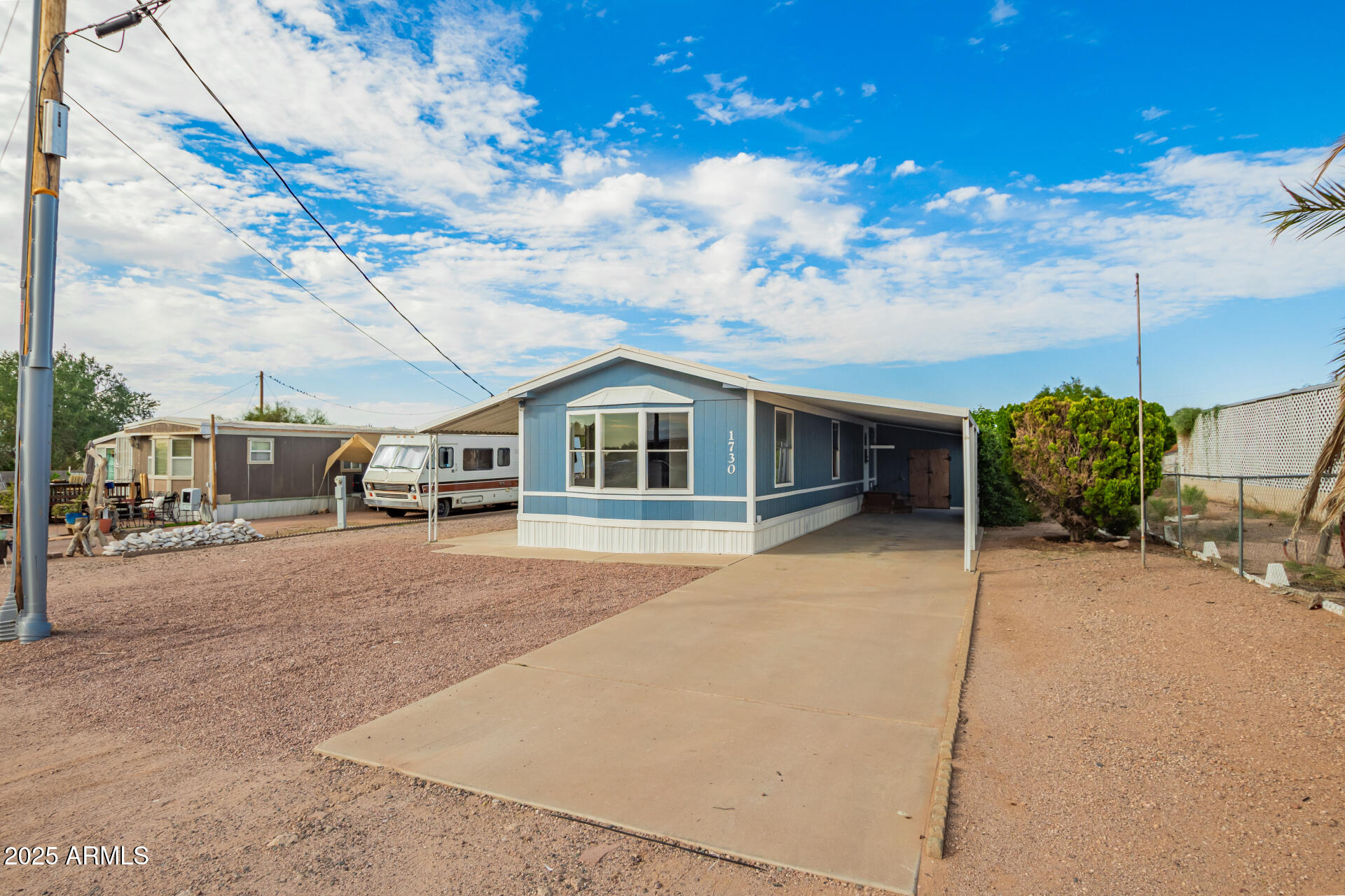 1730 East 21st Avenue Apache Junction, AZ 85119 - Photo 2 of 25 a front view of a house with a yard and garage