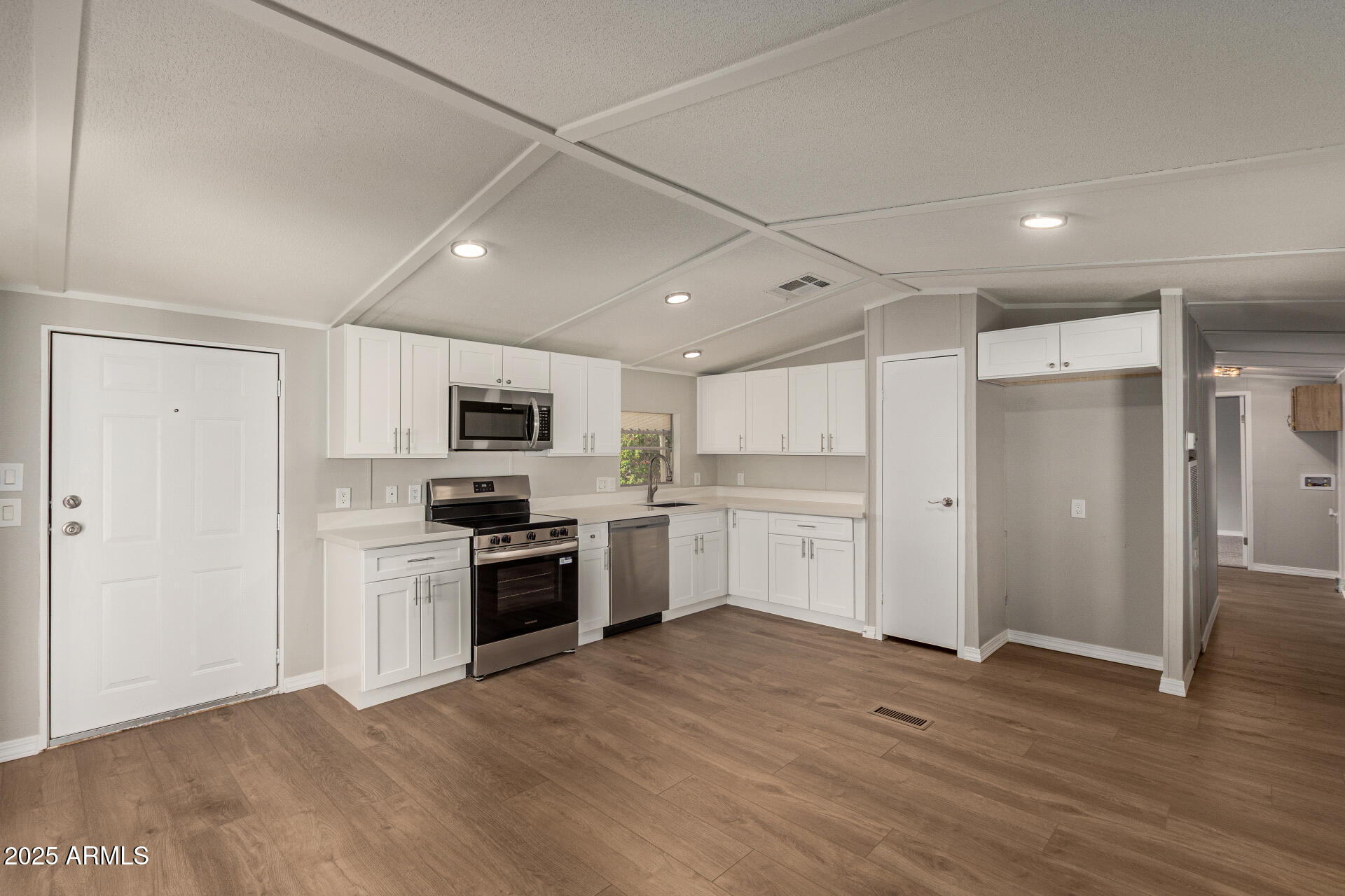 1730 East 21st Avenue Apache Junction, AZ 85119 - Photo 4 of 25 a large white kitchen with stainless steel appliances granite countertop a stove and a refrigerator
