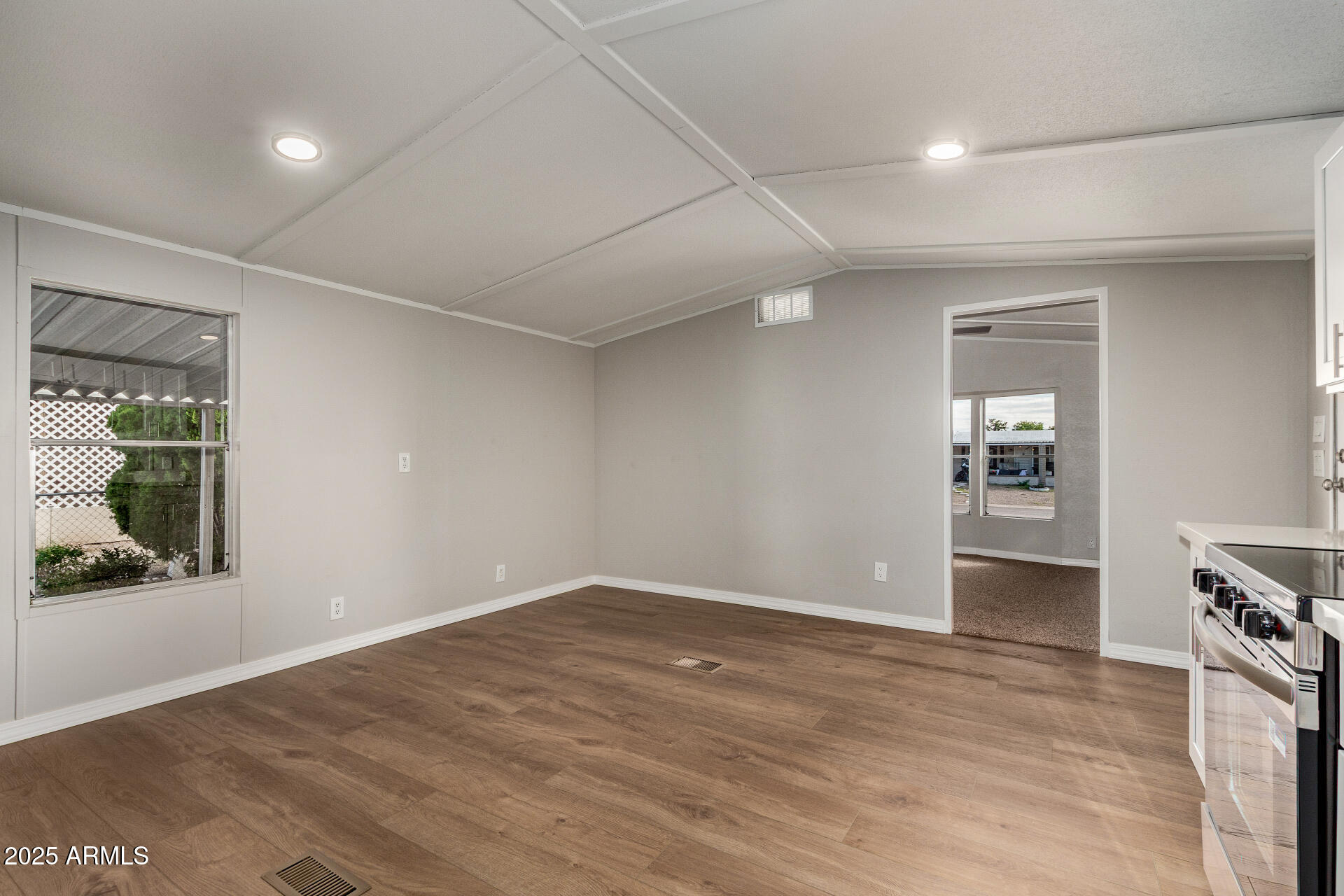 1730 East 21st Avenue Apache Junction, AZ 85119 - Photo 6 of 25 an empty room with wooden floor and windows