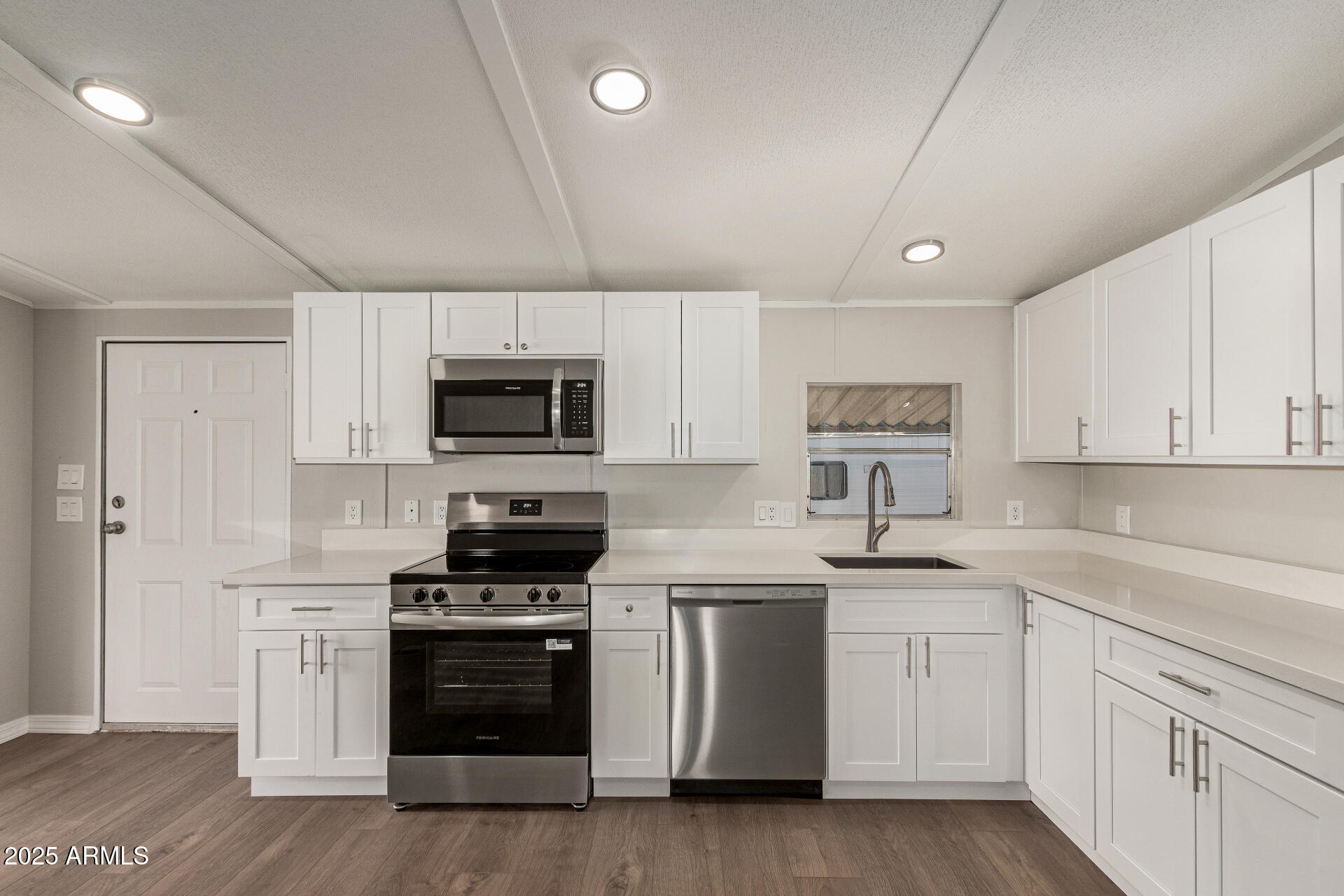 1730 East 21st Avenue Apache Junction, AZ 85119 - Photo 9 of 25 a kitchen with white cabinets stainless steel appliances and sink