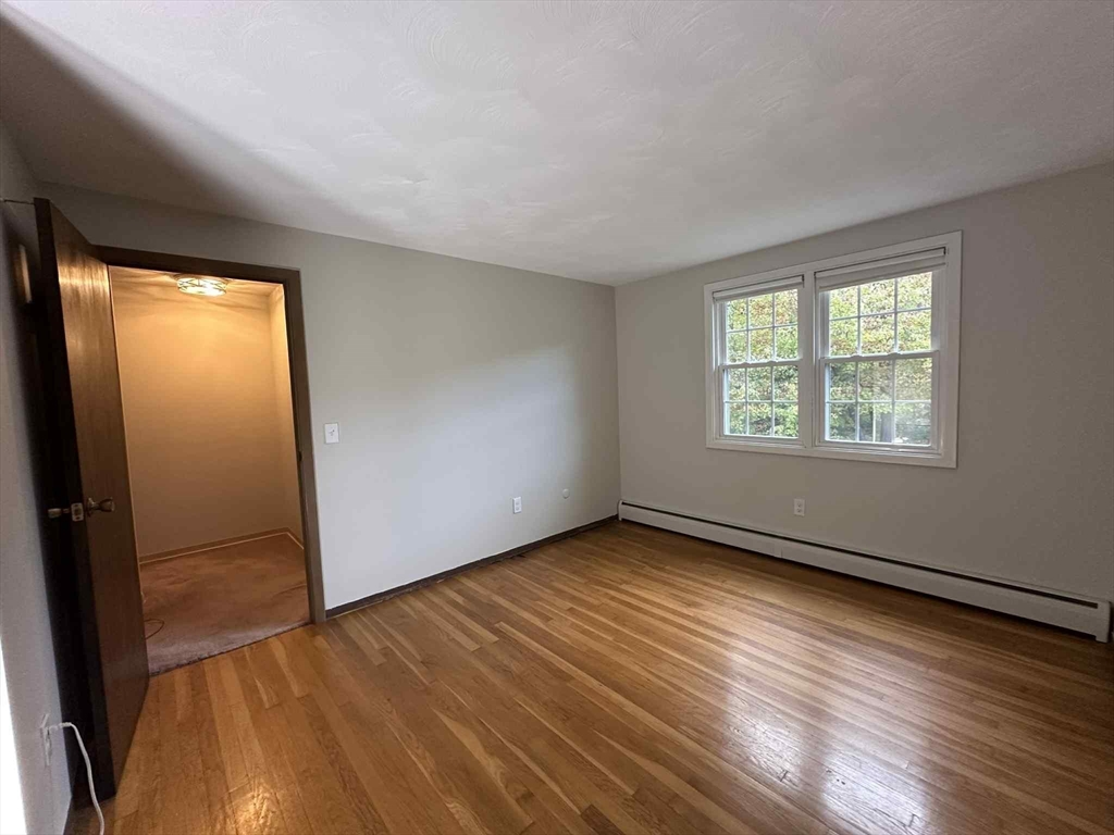 96 Coventry Circle, Unit 96 Brockton, MA 02301 - Photo 11 of 13 an empty room with wooden floor and windows