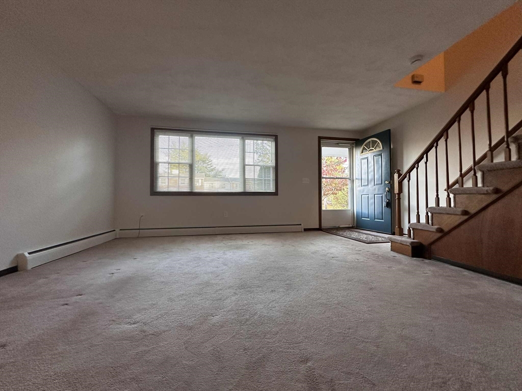 96 Coventry Circle, Unit 96 Brockton, MA 02301 - Photo 2 of 13 a view of an empty room with windows & stairs
