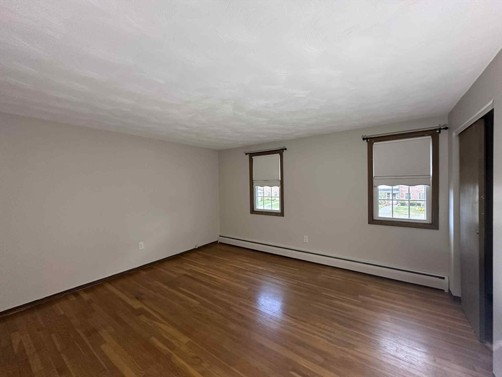 96 Coventry Circle, Unit 96 Brockton, MA 02301 - Photo 10 of 13 a view of an empty room with wooden floor and a window