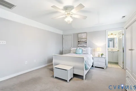 a spacious bedroom with a bed and a chandelier