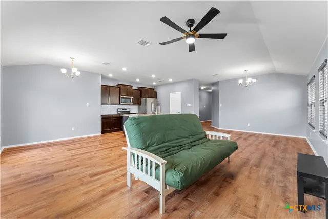 a view of kitchen with granite countertop cabinets and refrigerator