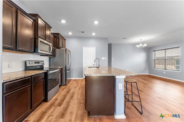 a kitchen with granite countertop lots of counter top space and stainless steel appliances