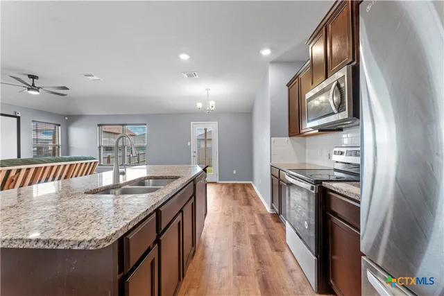 a kitchen with granite countertop a refrigerator and a sink