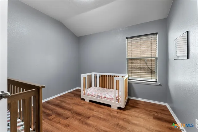 a spacious bedroom with a bed and a chandelier