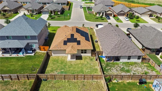 an aerial view of a city with lots of residential buildings and mountain view in back
