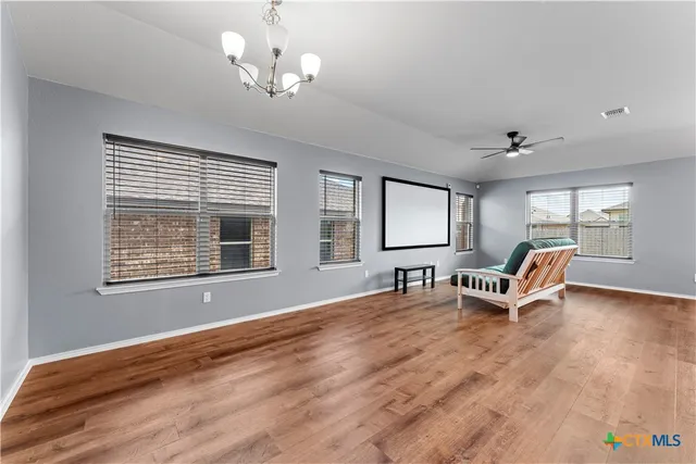 a living room with stainless steel appliances furniture and a wooden floor