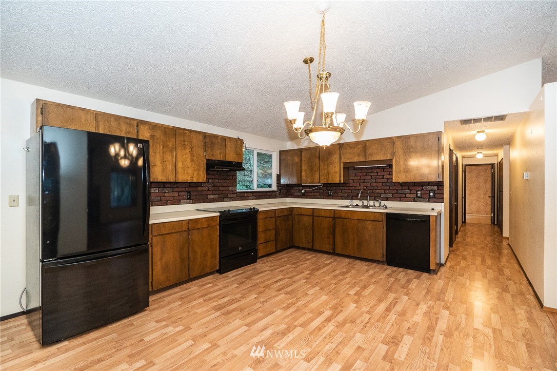 191 Tingle Road Winlock, WA 98596 - Photo 10 of 39 a kitchen with stainless steel appliances kitchen island granite countertop a refrigerator a stove a sink dishwasher a oven with a dining table and chairs