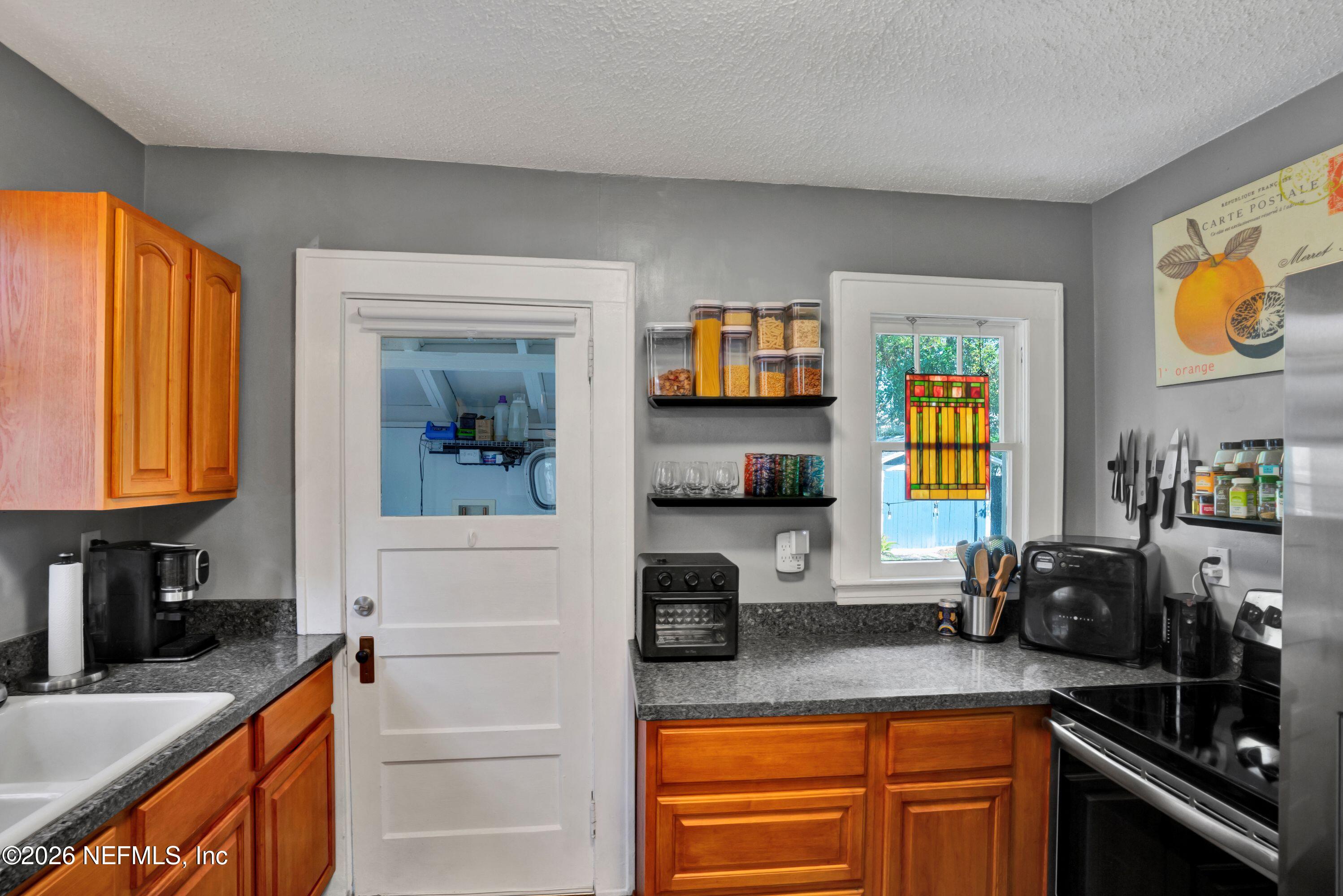 1273 Dancy Street Jacksonville, FL 32205 - Photo 14 of 30 a kitchen with stainless steel appliances granite countertop a sink stove and microwave