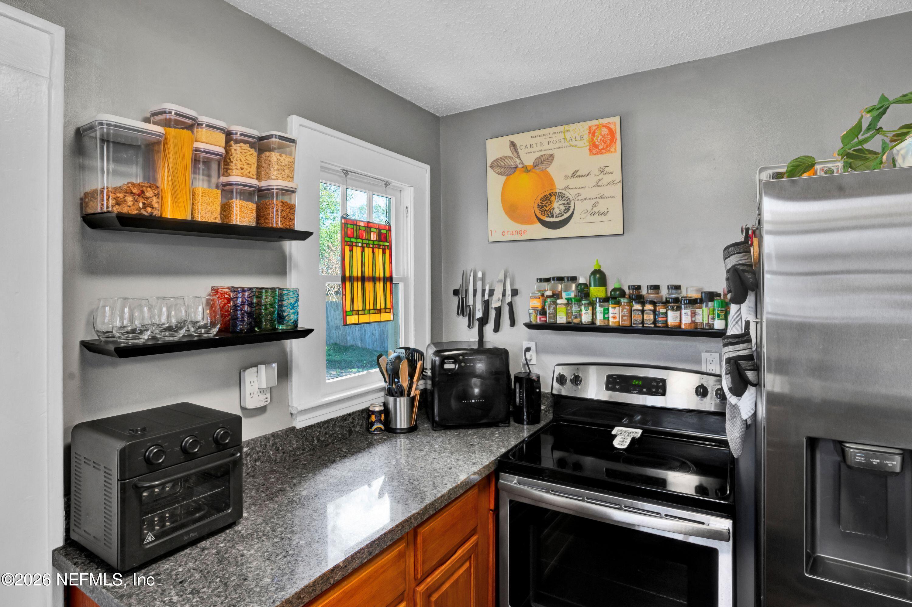 1273 Dancy Street Jacksonville, FL 32205 - Photo 15 of 30 a kitchen with stainless steel appliances kitchen island granite countertop a stove and a refrigerator
