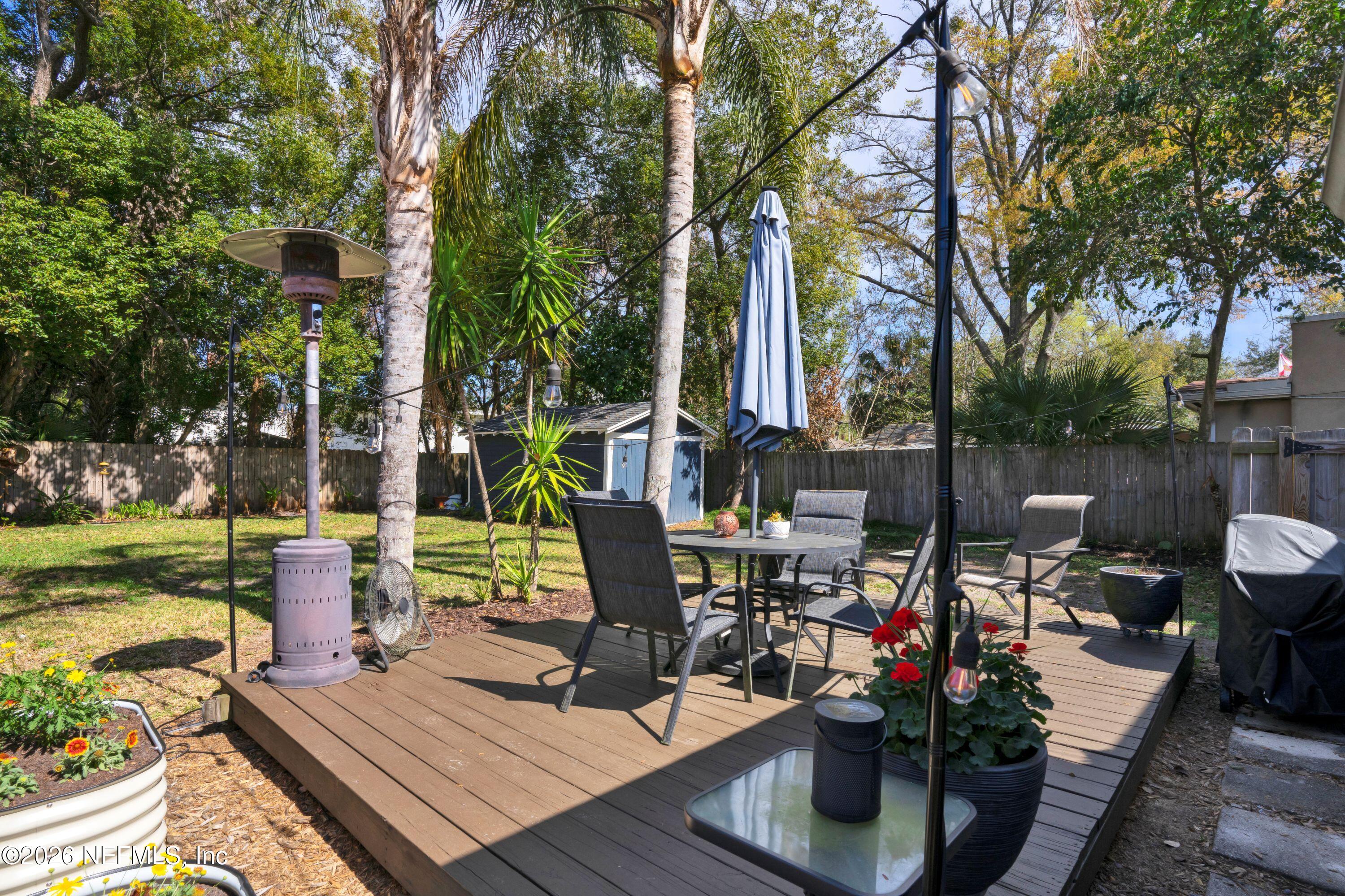 1273 Dancy Street Jacksonville, FL 32205 - Photo 25 of 30 a view of a patio with table and chairs potted plants and a large tree