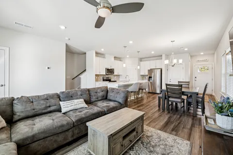 a living room with furniture kitchen view and a dining table