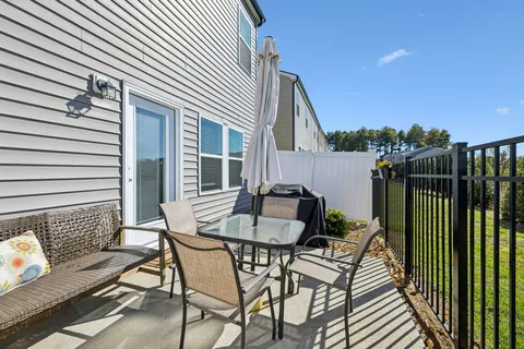 a view of a patio with a table and chairs and a barbeque