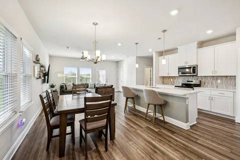a view of a dining room with furniture a chandelier and wooden floor