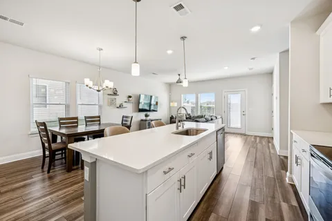 a large kitchen with kitchen island a island a stove a sink a center island a table and chairs