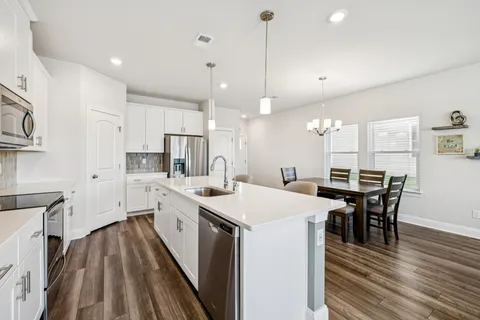 a large kitchen with a table and chairs