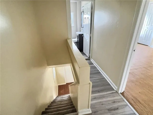 a view of stairs and hallway with wooden floor