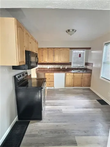 a kitchen with stainless steel appliances granite countertop a refrigerator stove top oven a sink and dishwasher