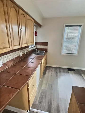 a spacious bathroom with a granite countertop sink and a mirror