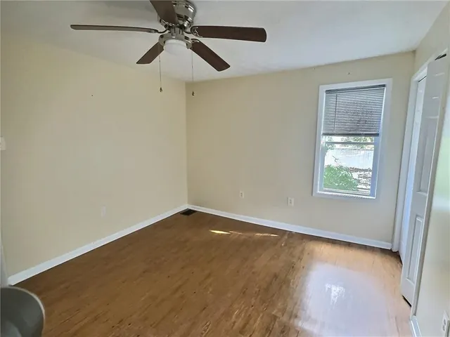 an empty room with a window and a ceiling fan