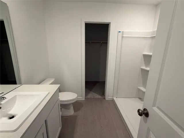 a bathroom with a sink a toilet a mirror and shower