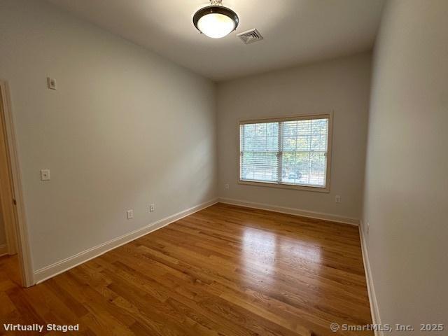 2518 Whitney Avenue, Unit 3 Hamden, CT 06518 - Photo 11 of 14 an empty room with wooden floor and windows