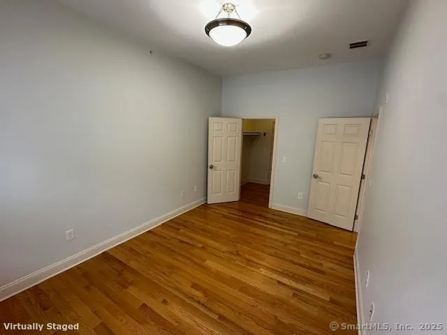 a view of empty room with wooden floor