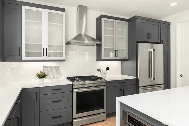 a kitchen with stainless steel appliances a stove and a refrigerator with white cabinets